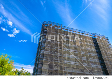 日本橫濱城市景觀：夏日天空蔓延…公寓大樓維修檢查的鷹架和防護網景觀（7月27日） 129002030