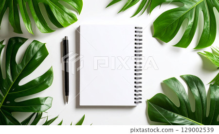 Minimal mockup of a white notebook and ballpoint pen | Simple top view composition with houseplants and natural light 129002539