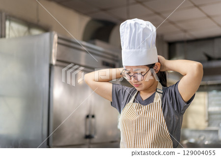 Young Chef Relaxing in Kitchen After Cooking Session 129004055