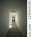 A modern, minimalist white long corridor leading to some residential apartments 129004580