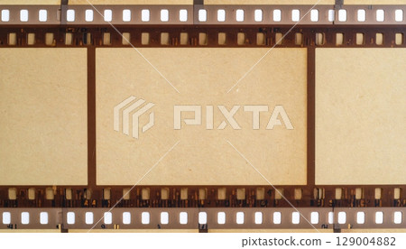Distressed vintage 35mm film strip frame with grunge texture, perfect for an aged photography or cinema background 129004882