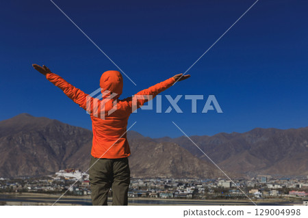 Woman open arms to the potala palace in Lhasa city,Tibet,China Woman open arms to the potala palace in Lhasa city,Tibet,China 129004998