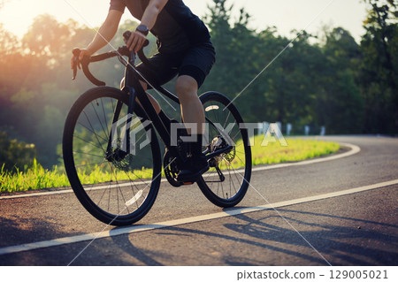 Cyclist riding bike at summer park 129005021