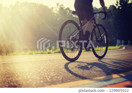 Cyclist riding bike at summer park 129005022