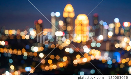 Bright Christmas city lights blur into a colorful night, illuminating festive trees and glowing street decorations 129005056