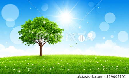 A lone tree stands majestically in a vast green field under a clear blue sky, illustrating the serene beauty of a natural summer landscape 129005101