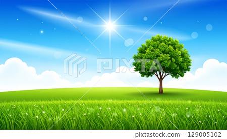 A lone tree stands majestically in a vast green field under a clear blue sky, illustrating the serene beauty of a natural summer landscape 129005102