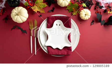 Red and white and red and green masks on a festive table setting with a holiday floral centerpiece Red and white and red and green masks on a festive table setting with a holiday floral centerpiece 129005189