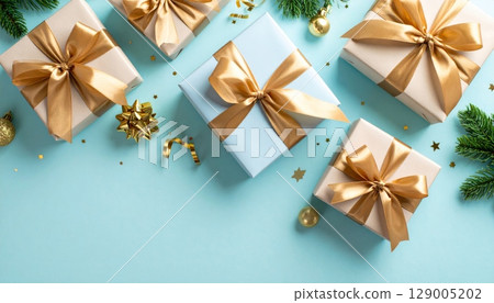 Golden Christmas gift box with a shiny red ribbon and bow, ready for a festive holiday celebration 129005202