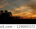 一架飛機在美麗的橙色夕陽中飛行 129005372