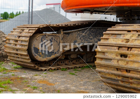 Heavy Excavator Tracks Durable Construction Equipment on a Construction Site Area Heavy Excavator Tracks Durable Construction Equipment on a Construction Site Area 129005902