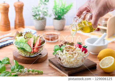 A table of colorful vegetable salads drizzled with olive oil 129006125