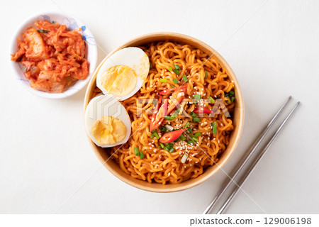 Top view of Spicy Korean dried instant noodles with boiled egg in kraft paper bowl and kimchi Top view of Spicy Korean dried instant noodles with boiled egg in kraft paper bowl and kimchi 129006198