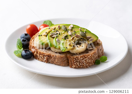 Avocado toast with banana, sunflower seed, pumpkin seed, sesame seed, blueberry and tomatoes Avocado toast with banana, sunflower seed, pumpkin seed, sesame seed, blueberry and tomatoes 129006211