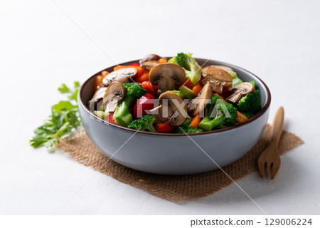 Stir fried vegetables, champignon mushroom, broccoli, bell pepper and carrot with soy sauce Stir fried vegetables, champignon mushroom, broccoli, bell pepper and carrot with soy sauce 129006224