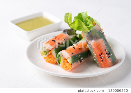 Salad roll with crab stick, carrot, cucumber and lettuce wrapped with rice paper Salad roll with crab stick, carrot, cucumber and lettuce wrapped with rice paper 129006250