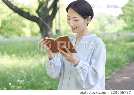 Woman reading outdoors 129006727