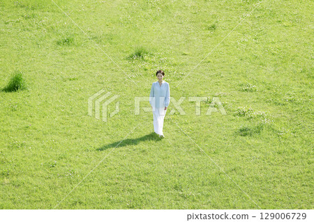 Aerial view of a woman walking in the fields Aerial view of a woman walking in the fields 129006729