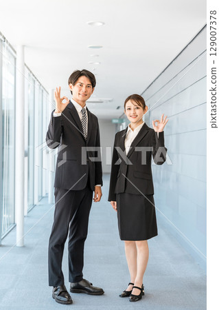 Young Asian businessmen and women in suits standing in the office corridor (ok, recommended, success) 129007378
