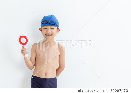A boy wearing a swimsuit holding a Maru plate 129007470
