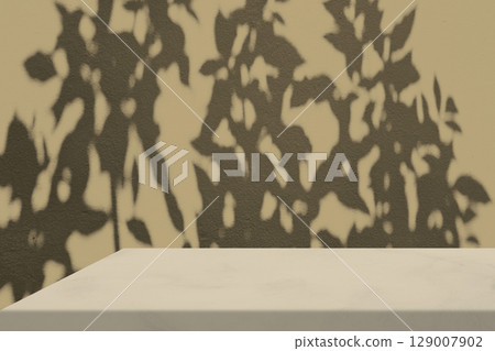 Marble Table Corner with Light Beam, Shadow, and Spotlight on the Beige Concrete Wall Background 129007902