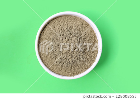 Gotu kola powder (Centella asiatica) in a wooden spoon on white background. 129008555