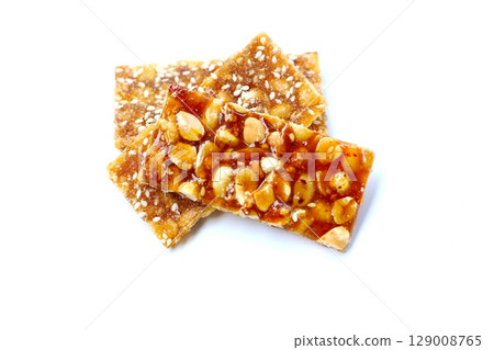 Crispy peanut brittle bars coated in glossy caramel. Crispy peanut brittle bars coated in glossy caramel. 129008765