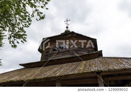 Rustic Wooden Church with Cross Under an Overcast Sky 129009032