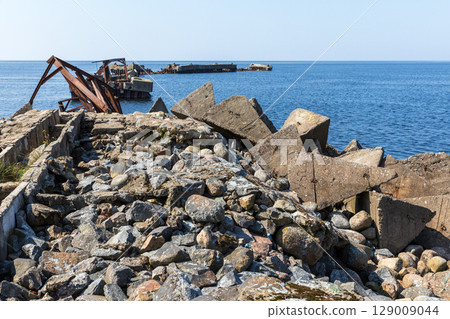 Old Damaged Pier With Ruins by a Serene Blue Sea 129009044
