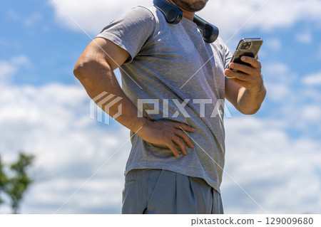 Stock photo of a man wearing a neck cooler. A bearded man wearing a gray T-shirt. 129009680