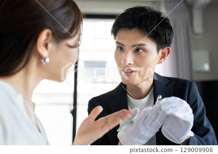 一位女士正在接受珠寶鑑定，鑑定師 129009908