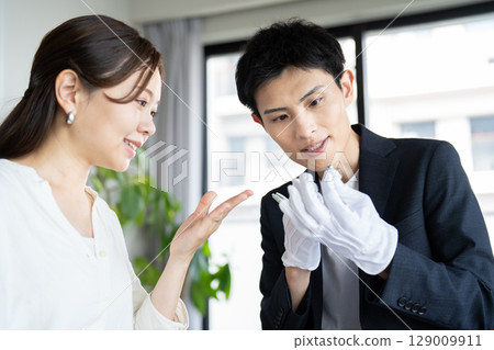 一位女士正在接受珠寶鑑定，鑑定師 129009911