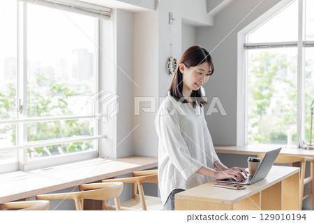 站在設計師辦公室裡使用筆記型電腦的女士 129010194