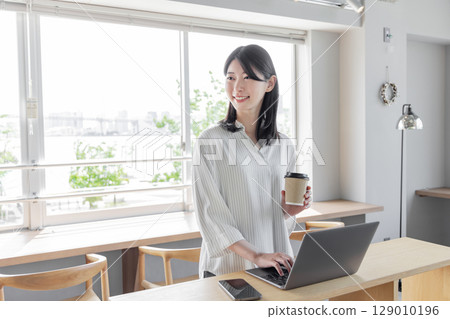站在創意辦公室使用筆記型電腦的女性 站在創意辦公室使用筆記型電腦的女性 129010196