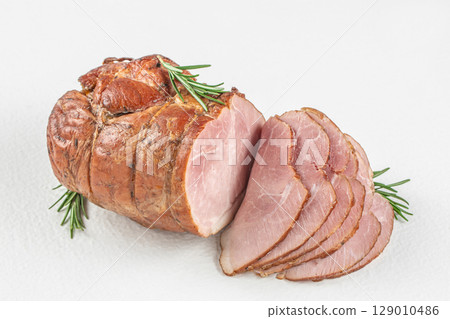 Smoked ham roast with rosemary sliced on a white background 129010486