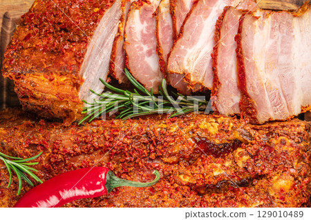 Spicy baked ham with chili crust and rosemary, sliced and ready to serve 129010489