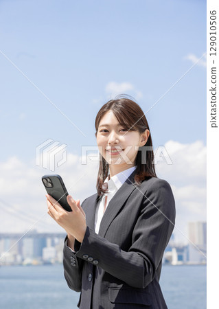 Business woman searching on smartphone Business woman searching on smartphone 129010506