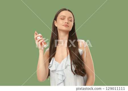 Woman applying perfume in a soothing setting 129011111