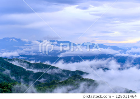 Beautiful view of mountains and sky covered with clouds and mist 129011464