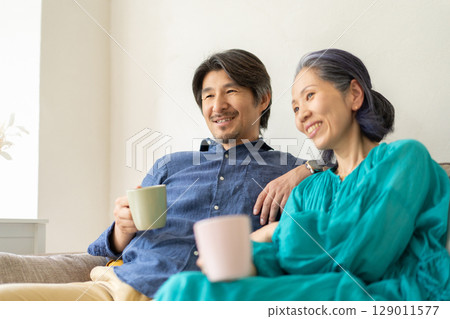 放鬆在長沙發的男人和婦女 放鬆在長沙發的男人和婦女 129011577