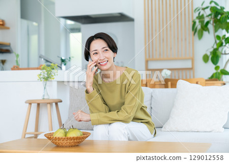 Middle woman calling in the living room 129012558