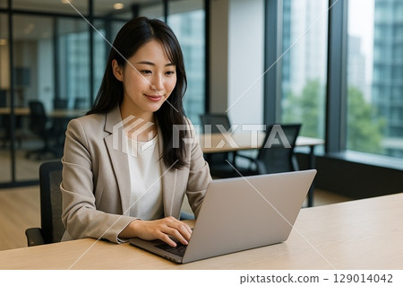 Young Japanese woman using laptop in office | Business scene and white space 129014042