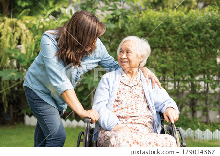 Caregiver help and care Asian senior woman patient sitting on wheelchair at nursing hospital ward, healthy strong medical. Caregiver help and care Asian senior woman patient sitting on wheelchair at nursing hospital ward, healthy strong medical. 129014367