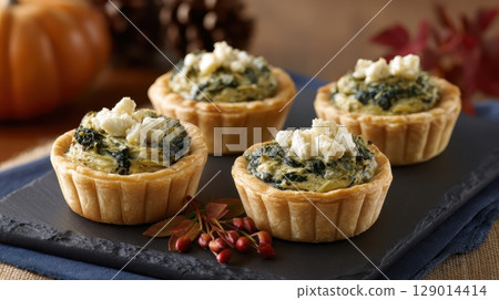 Mini tartlets filled with creamy spinach and artichoke 129014414
