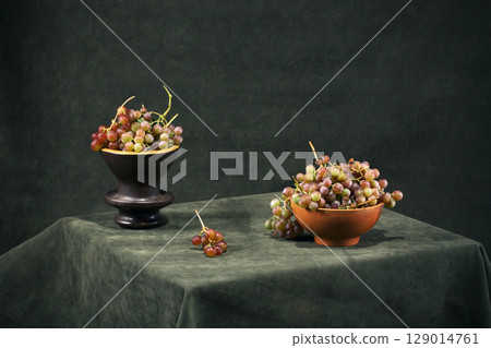 Still life with ripe grapes in plates on the table 129014761