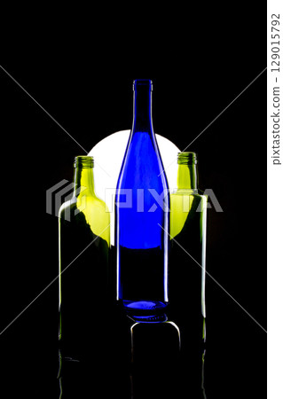 Still life with glass bottles on a light circle background Still life with glass bottles on a light circle background 129015792