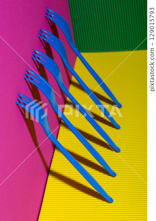 Abstract still life with blue forks on a colored background Abstract still life with blue forks on a colored background 129015793