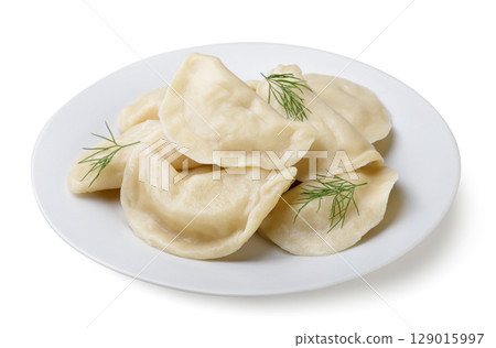 Boiled dumplings with dill leaves in a plate on a white background. Isolated Boiled dumplings with dill leaves in a plate on a white background. Isolated 129015997