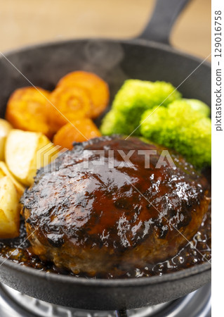 Hot demi-glace hamburger steak cooked in a skillet Hot demi-glace hamburger steak cooked in a skillet 129016758