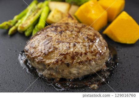 Juicy hamburger steak and vegetables grilled on a hot plate Juicy hamburger steak and vegetables grilled on a hot plate 129016760